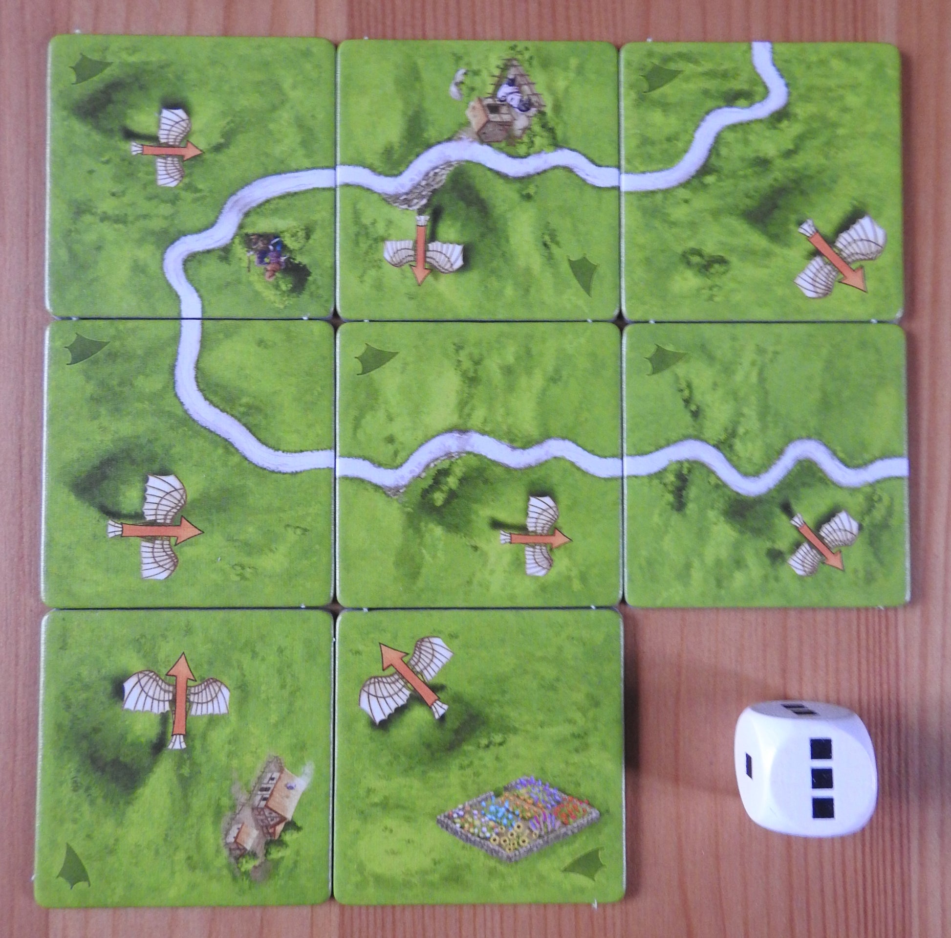 View of all the tiles and the die included in this Carcassonne Flying Machines mini expansion.