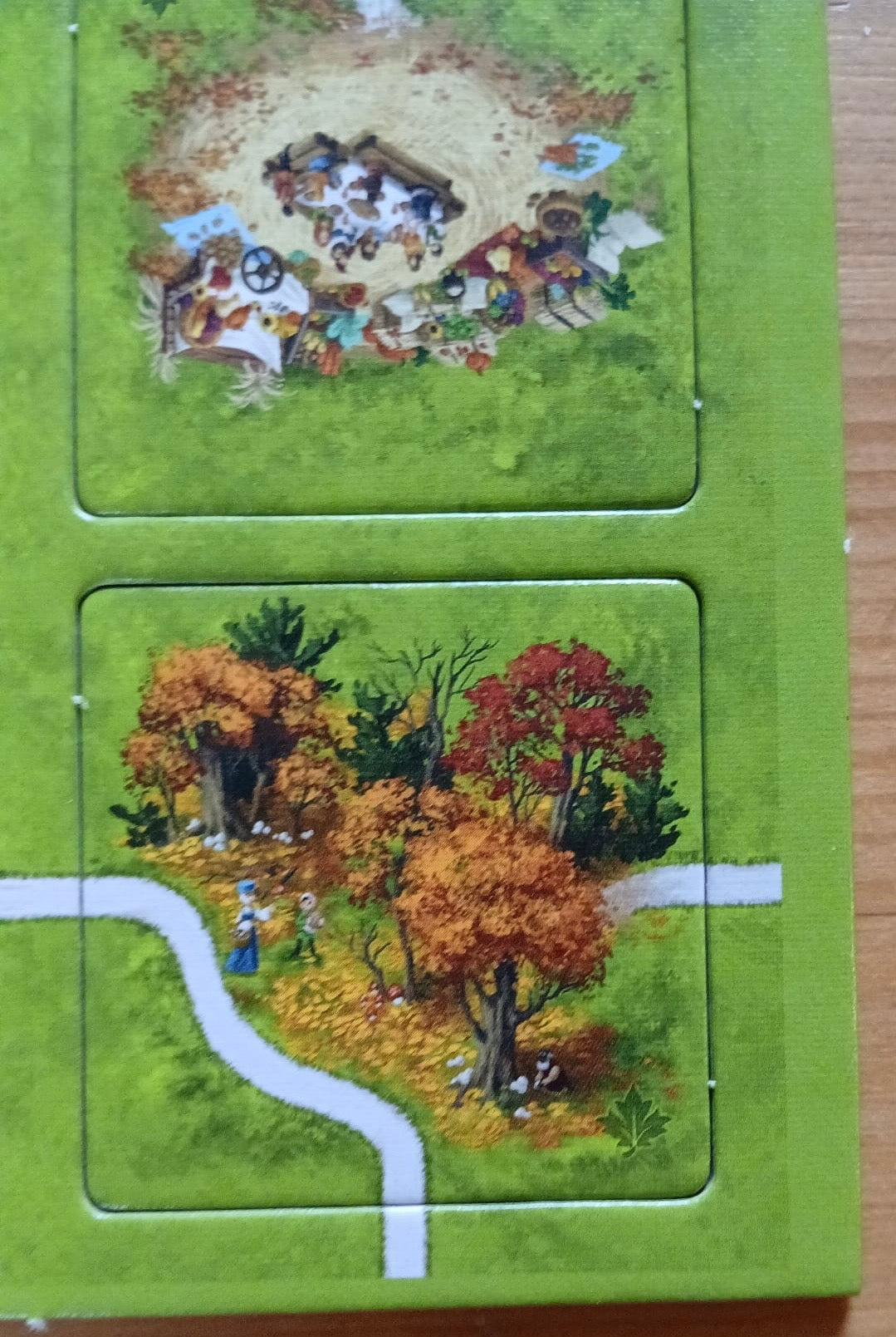 Close-up of two of the lovely included tiles, including a beautiful autumnal forest in this Autumn mini expansion for the Carcassonne board game.