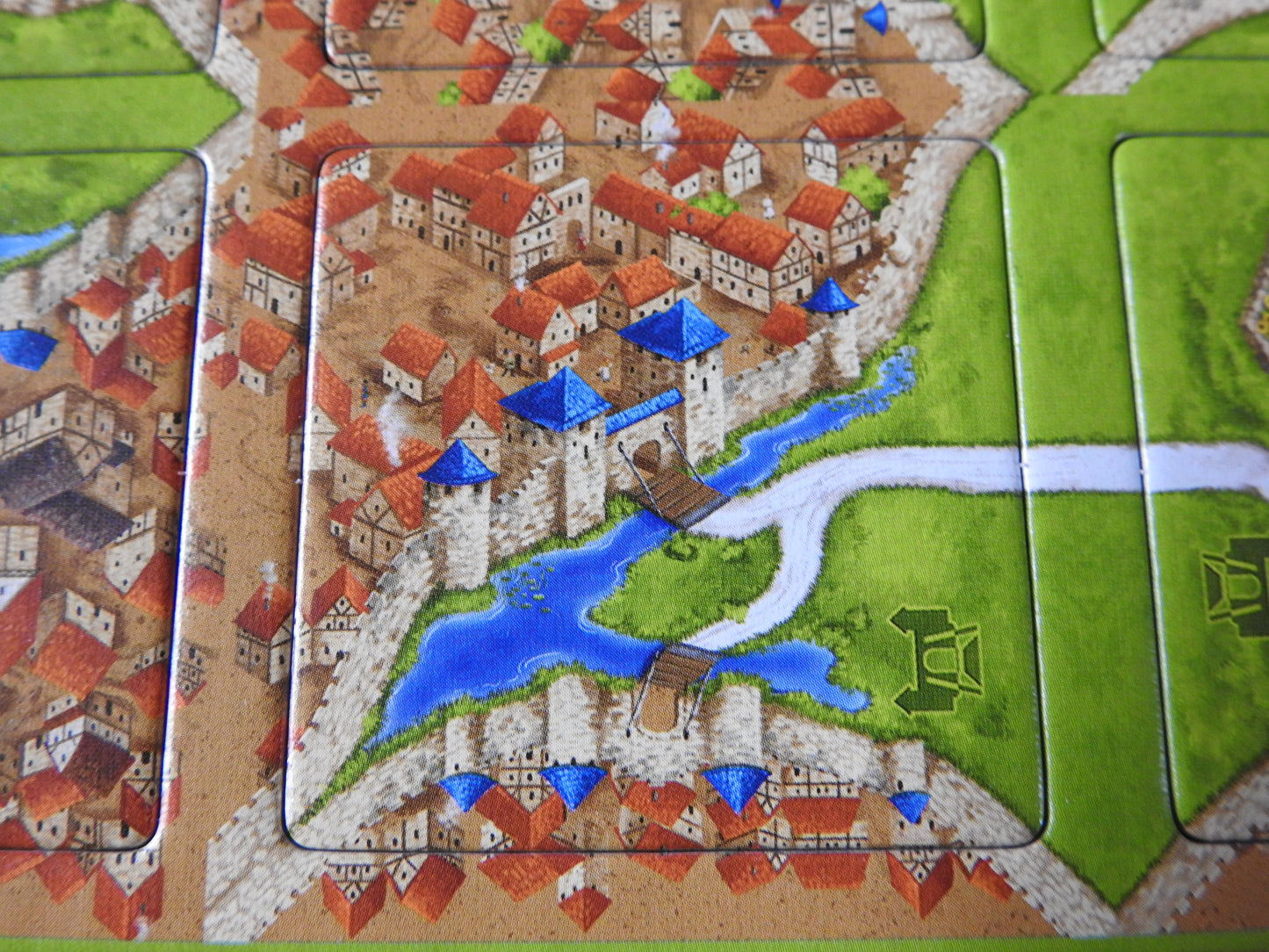 Close-up view of one of the beautiful tiles, featuring a beatiful drawbridge across a moat to the city in this Carcassonne Drawbridges mini expansion.