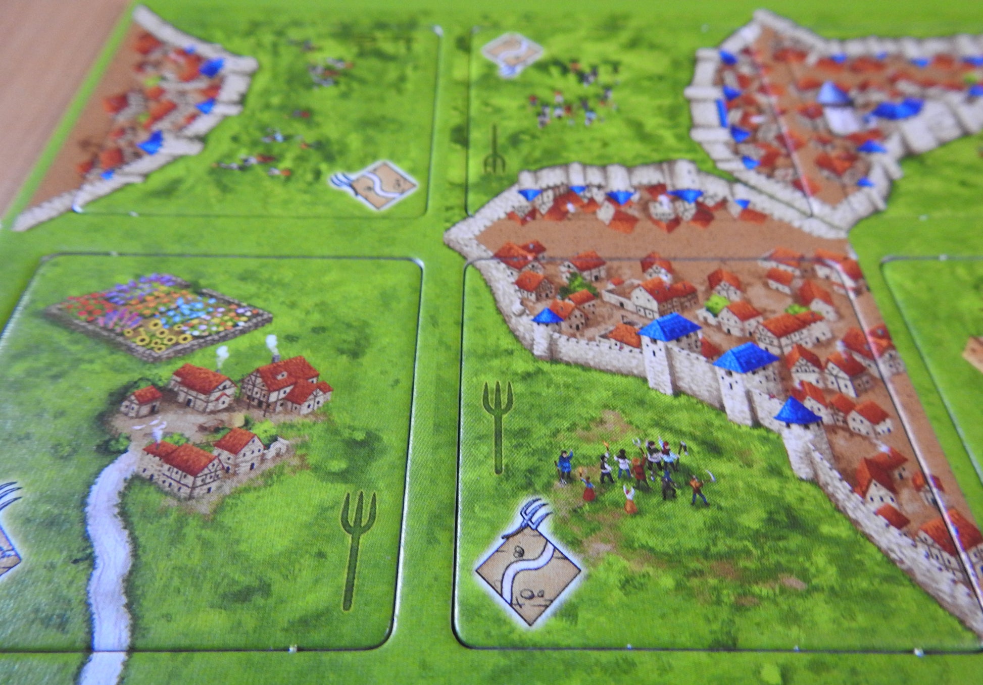 Close-up view of more of the tiles, each featuring a pitchfork watermark symbol in this Peasant Revolts mini expansion for Carcassonne.