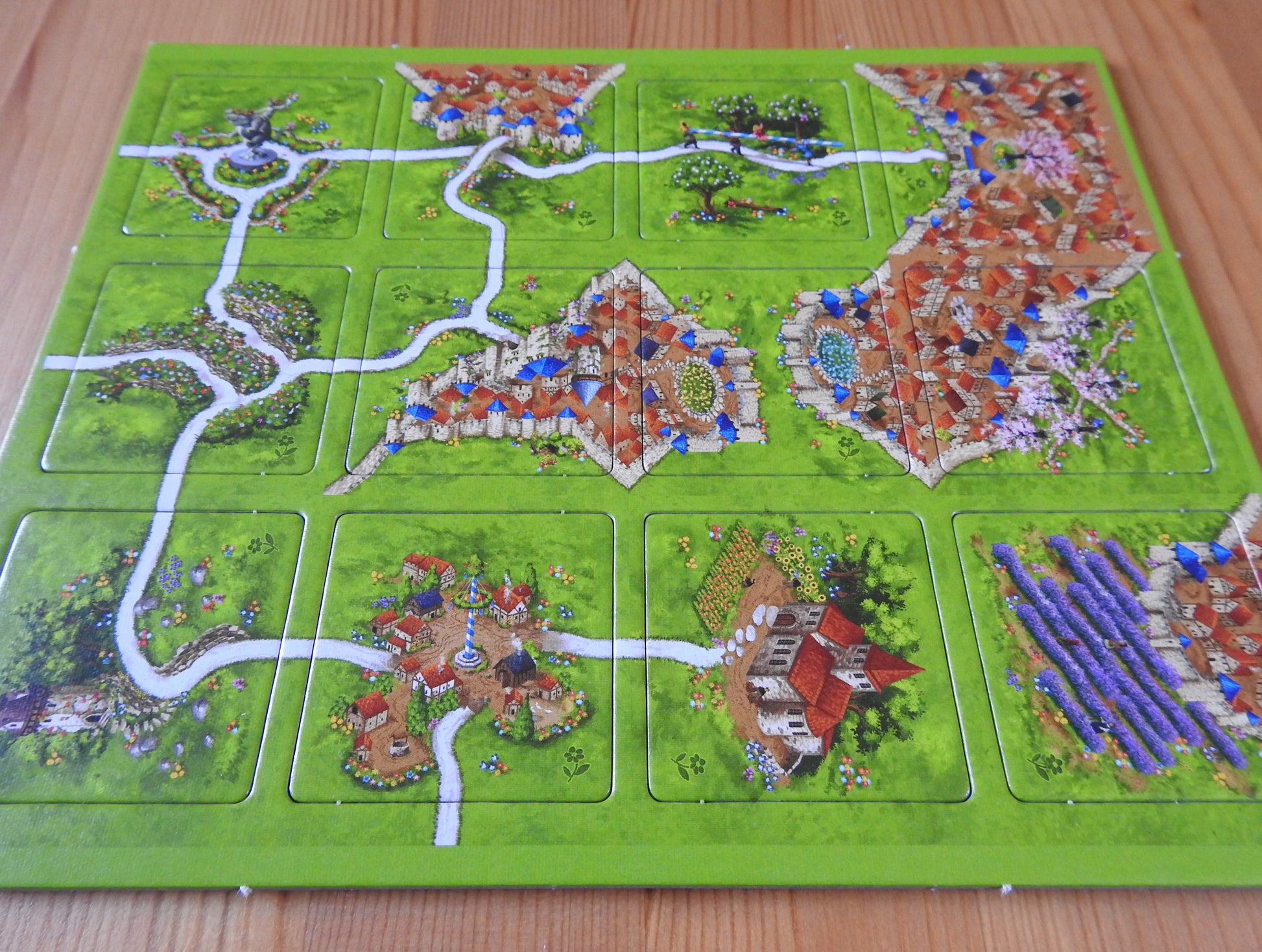 A view of all 12 of the included tiles from a lower angle in this Spring mini expansion for Carcassonne.