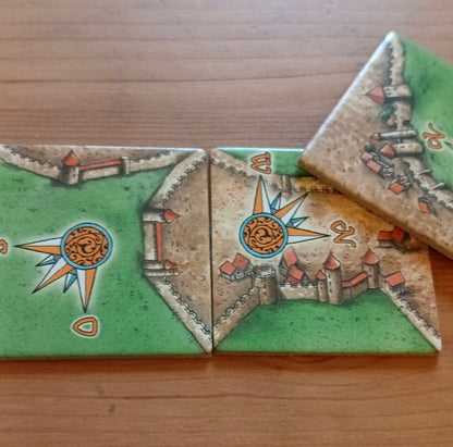 View of 3 more of the included tiles, with other parts of the windrose compasses showing in this Windrose I mini expansion for the Carcassonne board game.