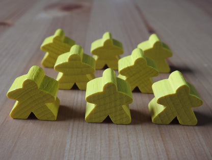 Close-up view of the yellow set of 8 meeples.