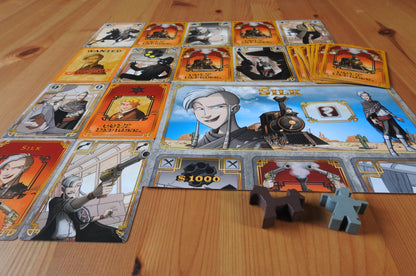 Closer view showing the cards, character sheet and wooden pieces included in the Colt Express Silk Bandit mini expansion.