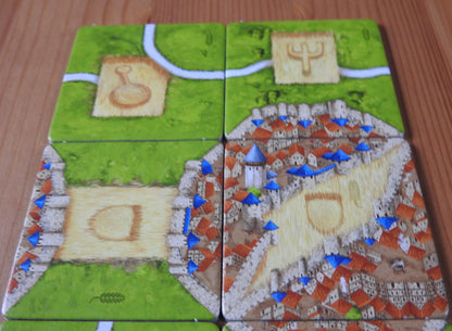 View of 4 of the tiles, showing a range of roads, cities and cornfields in this Carcassonne Corn Circles II expansion.