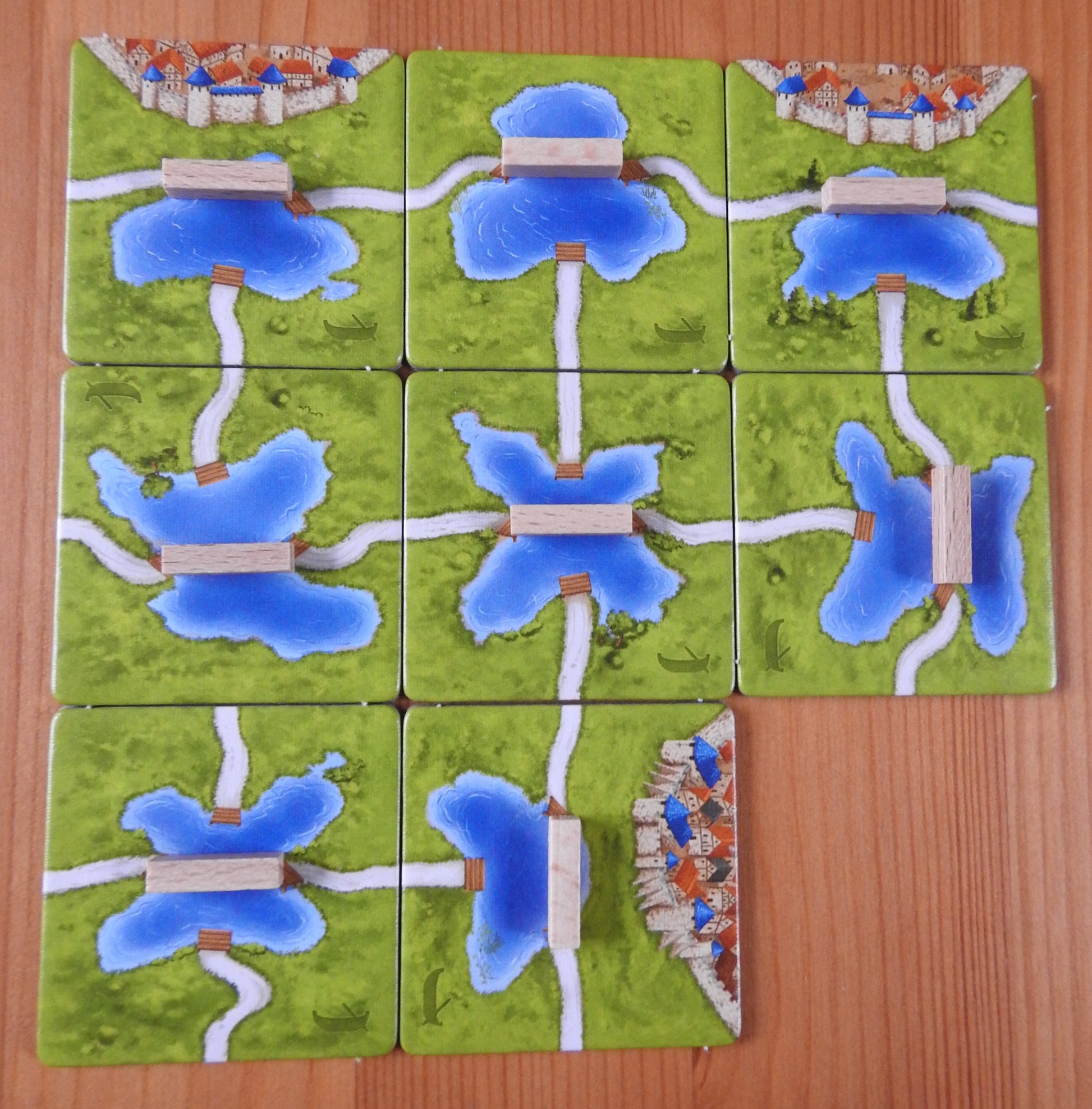 Another view from above of all 8 tiles and 8 wooden ferry pieces in this Carcassonne Ferries expansion.