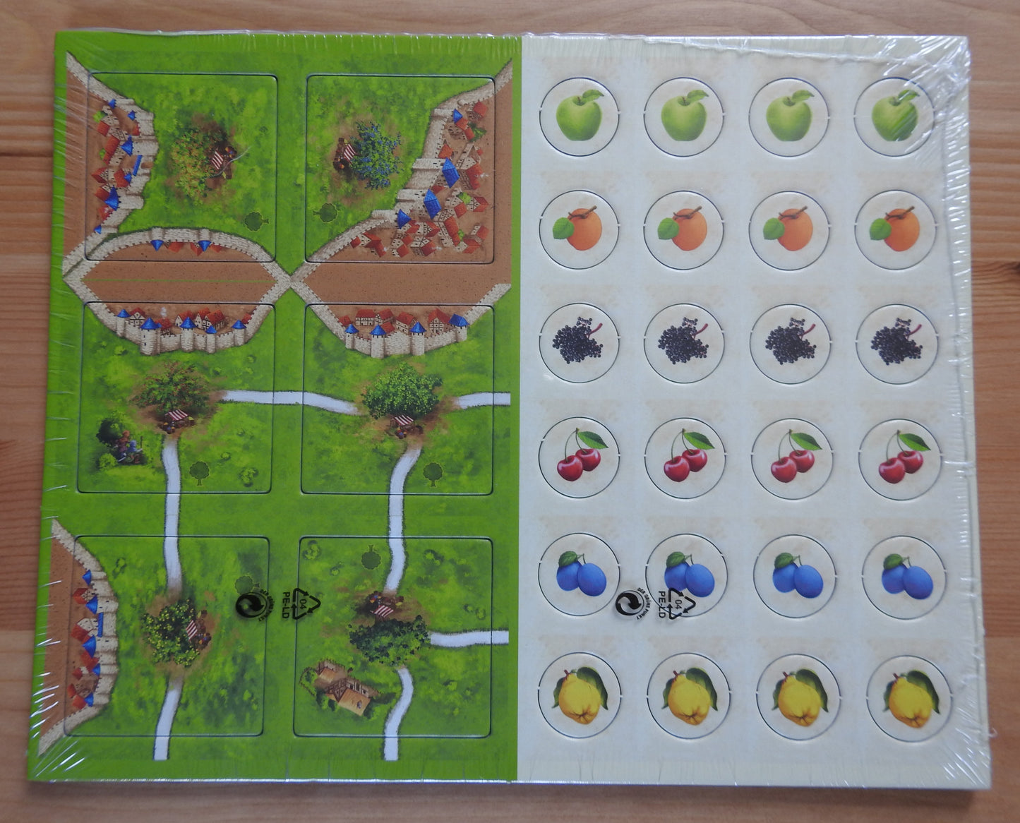 Front view of the Fruit Bearing Trees Carcassonne mini expansion, showing the 6 tiles and 24 counters.