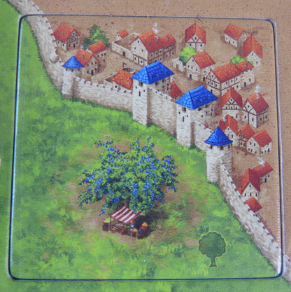 Close-up of one of the tiles showing a city's wall with a fruit tree standing outside.