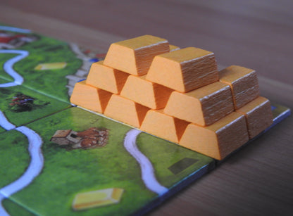 A view of all the wooden gold bar pieces that come with this Carcassonne Gold Mines mini expansion.