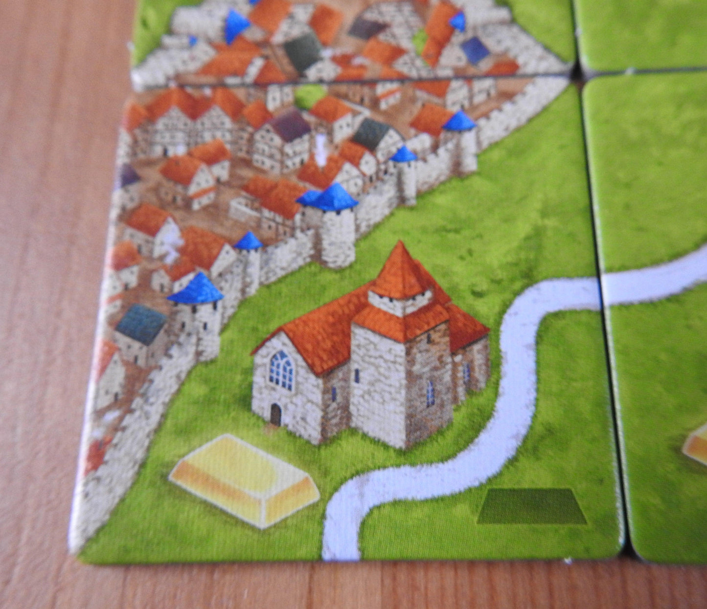 A final view of a landscape tile showing part of a city and a road, that is included in this Carcassonne Gold Mines expansion.