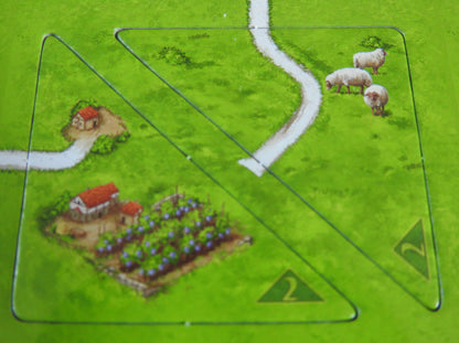 Close-up of 2 half tiles showing sheep in a field and a house and lovely garden!