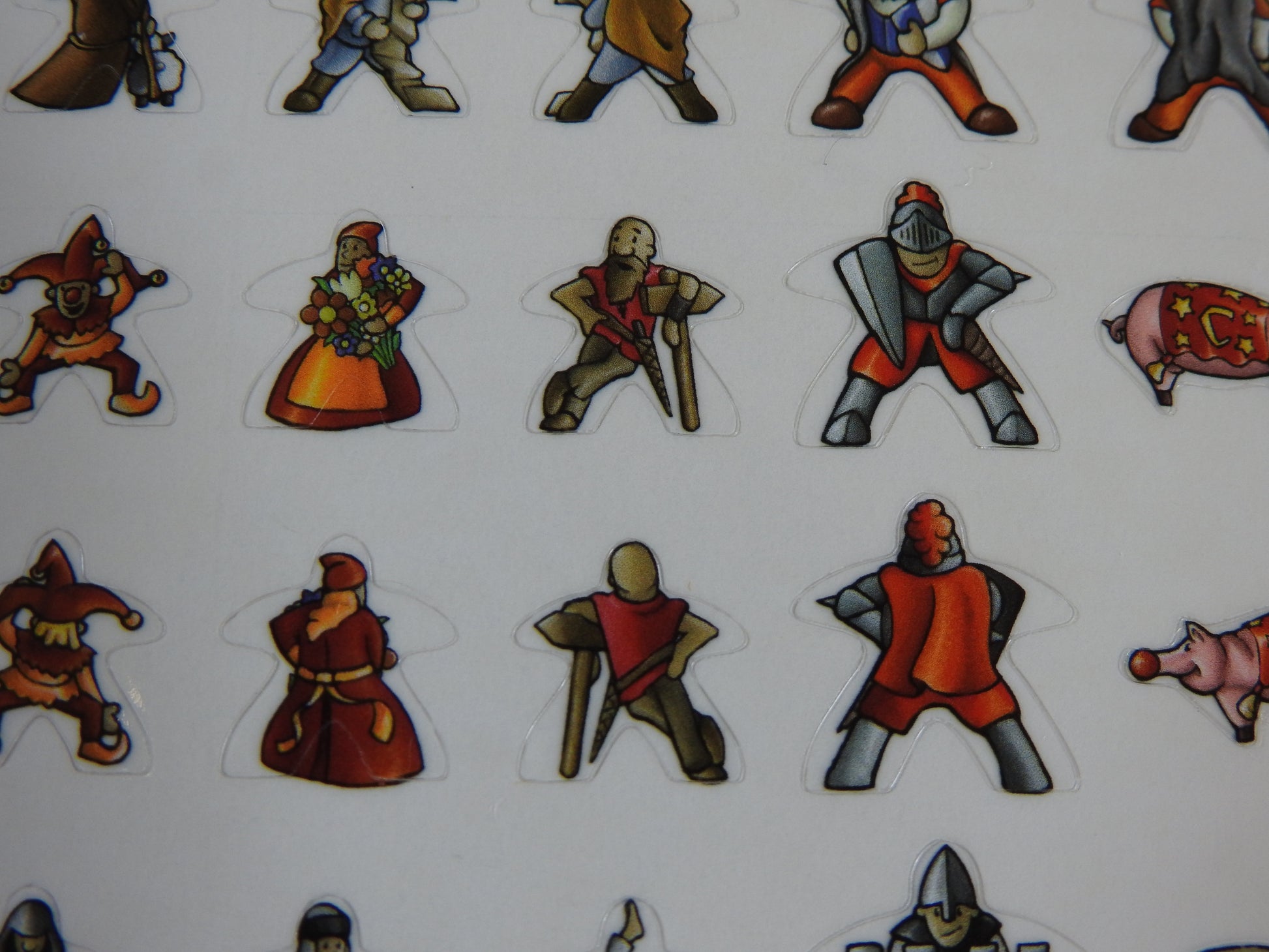 Close-up of two rows of Carcassonne meeple stickers, showing medieval knights and wizards.