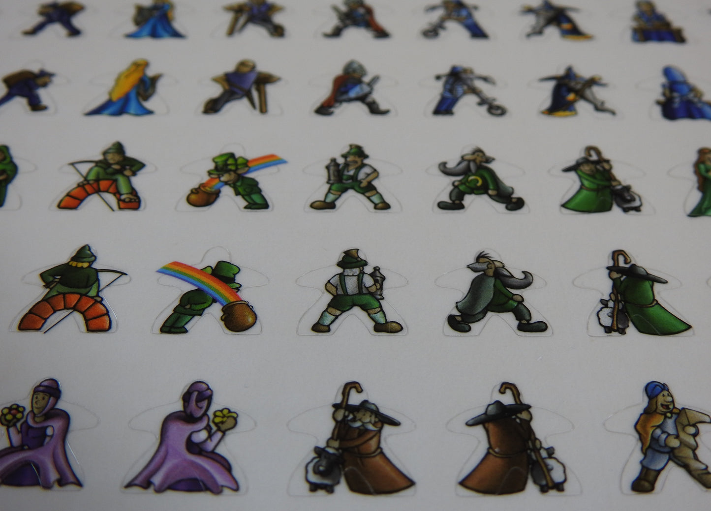 Close-up of five rows of Carcassonne meeple stickers, showing leprechauns and shepherds.
