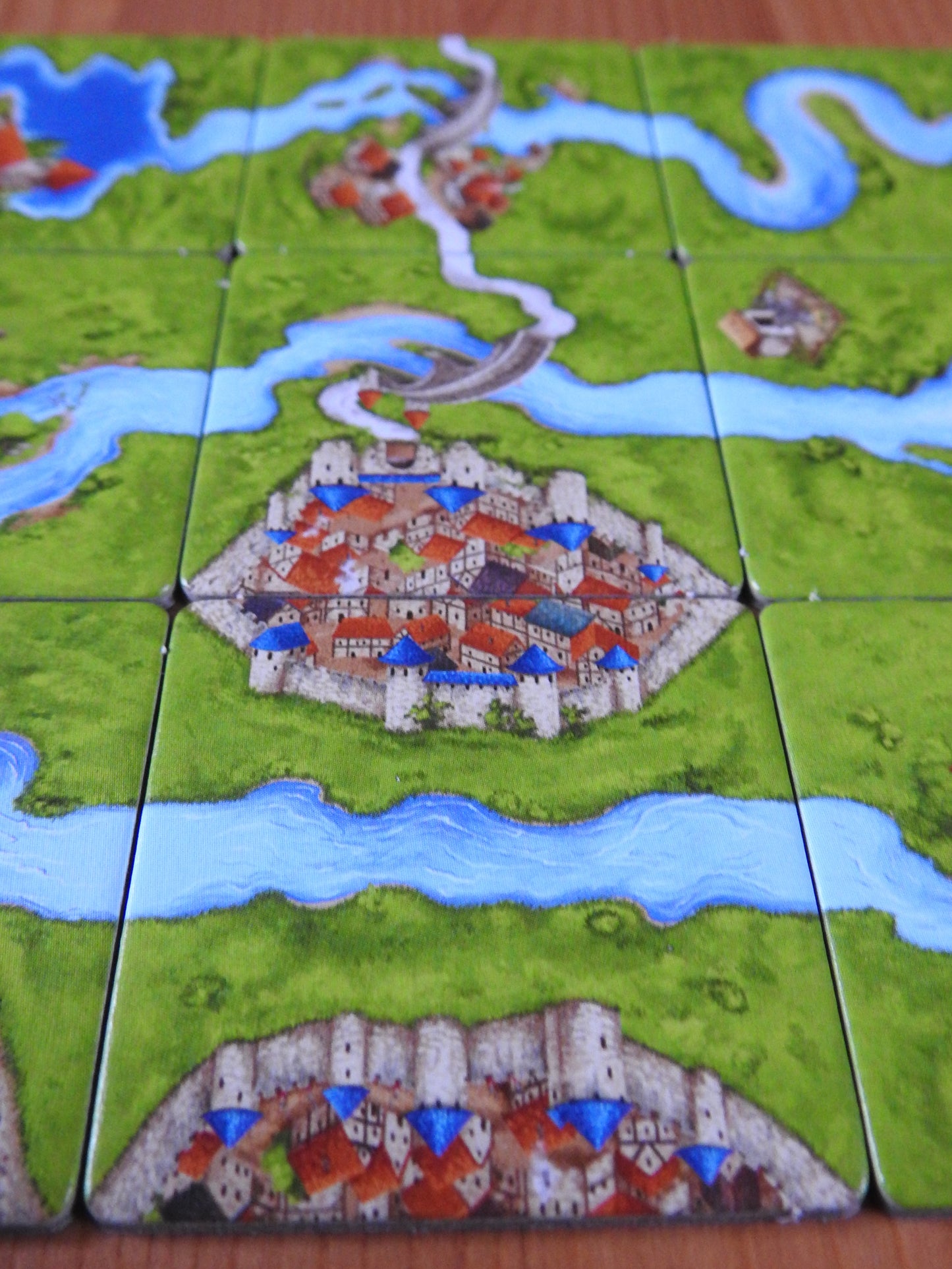 Close-up of some of the tiles, showing a lovely blue river winding its way through the lush landscape in this River I mini expansion for Carcassonne.