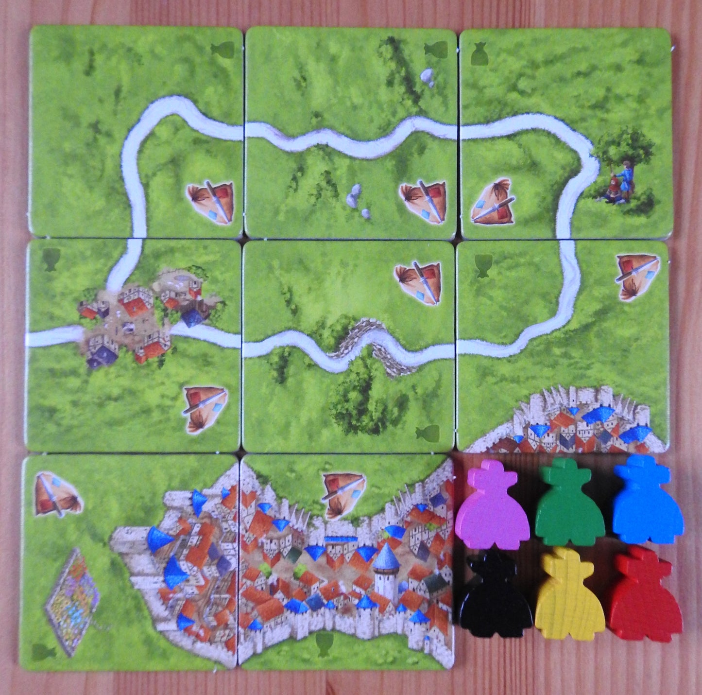 View of all the landscape tiles and meeple figures included in this Carcassonne Robbers expansion.