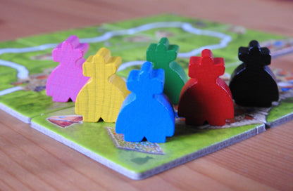 Close-up of all 6 of the wooden robber meeple figures included in this Carcassonne Robbers expansion.