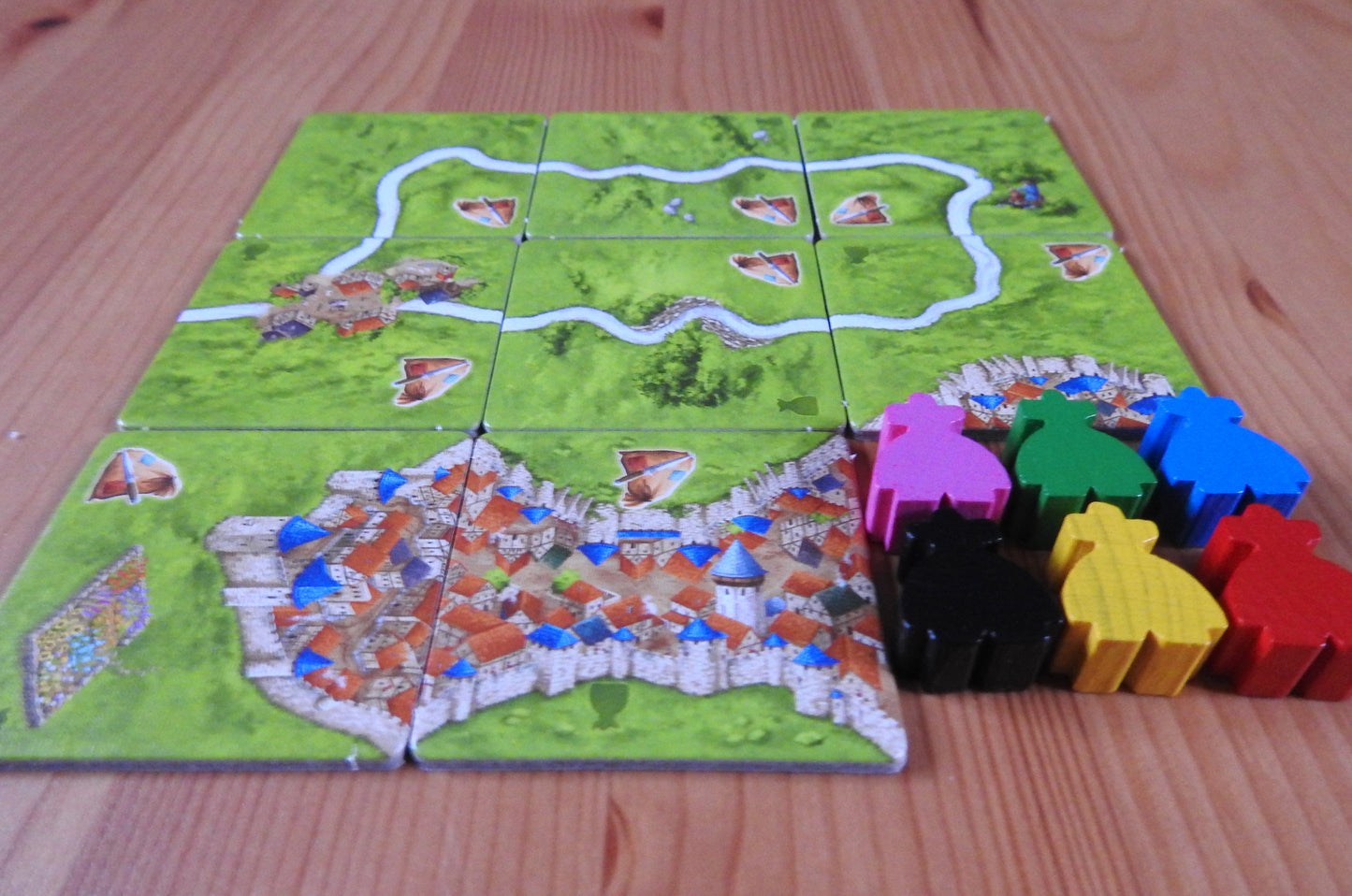 Another view showing all 6 wooden meeple figures next to the tiles in this Carcassonne Robbers expansion.