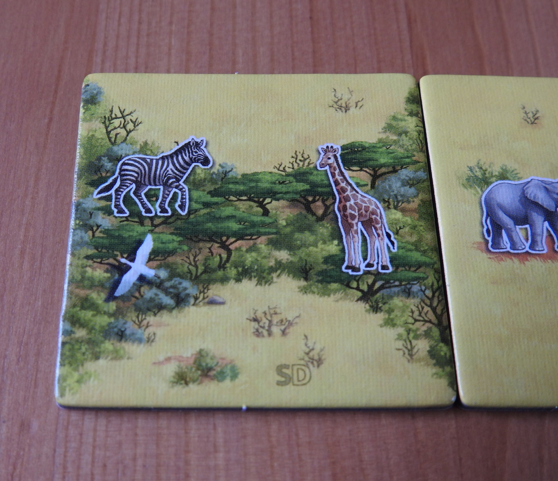Closer view of one of the included tiles, featuring a zebra, a giraffe and a bird flying overhead in this Spiel Doch 2 Tile Promo for Carcassonne Safari.