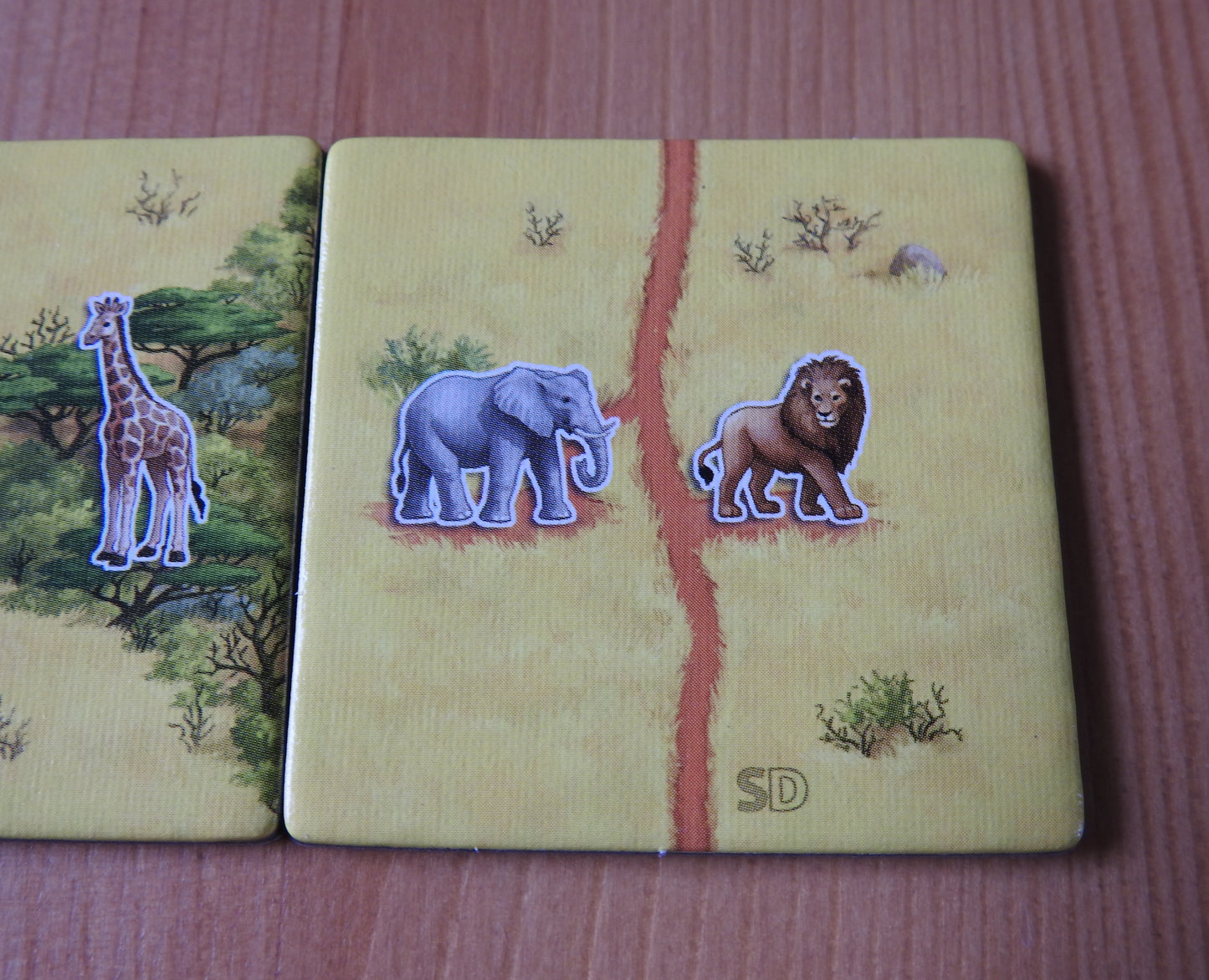 Closer view of the other included tile, showing a lion and an elephant next to a straight track in this Spiel Doch 2 Tile Promo for Carcassonne Safari.
