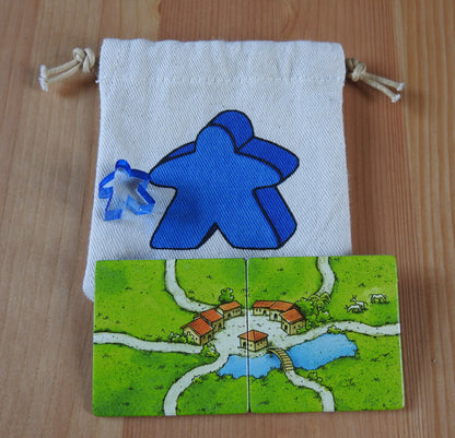 Close-up of the blue meeple bag, blue meeple teacher and 2 tiles.