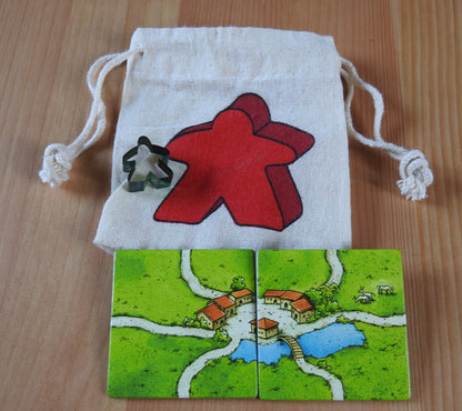 Close-up of the red meeple bag, green meeple teacher and 2 tiles.