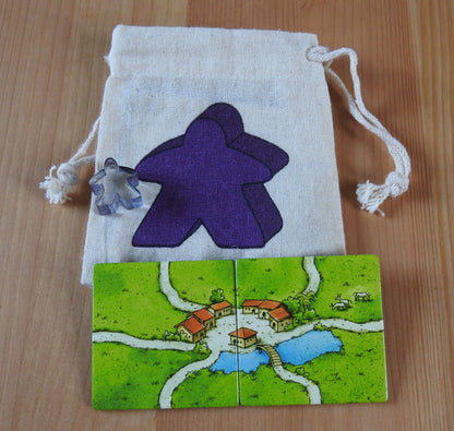 Close-up of the purple meeple bag, purple meeple teacher and 2 tiles.
