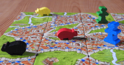 View of some more of the wooden pieces shown on the tiles of this Carcassonne Traders & Builders Unboxed expansion.