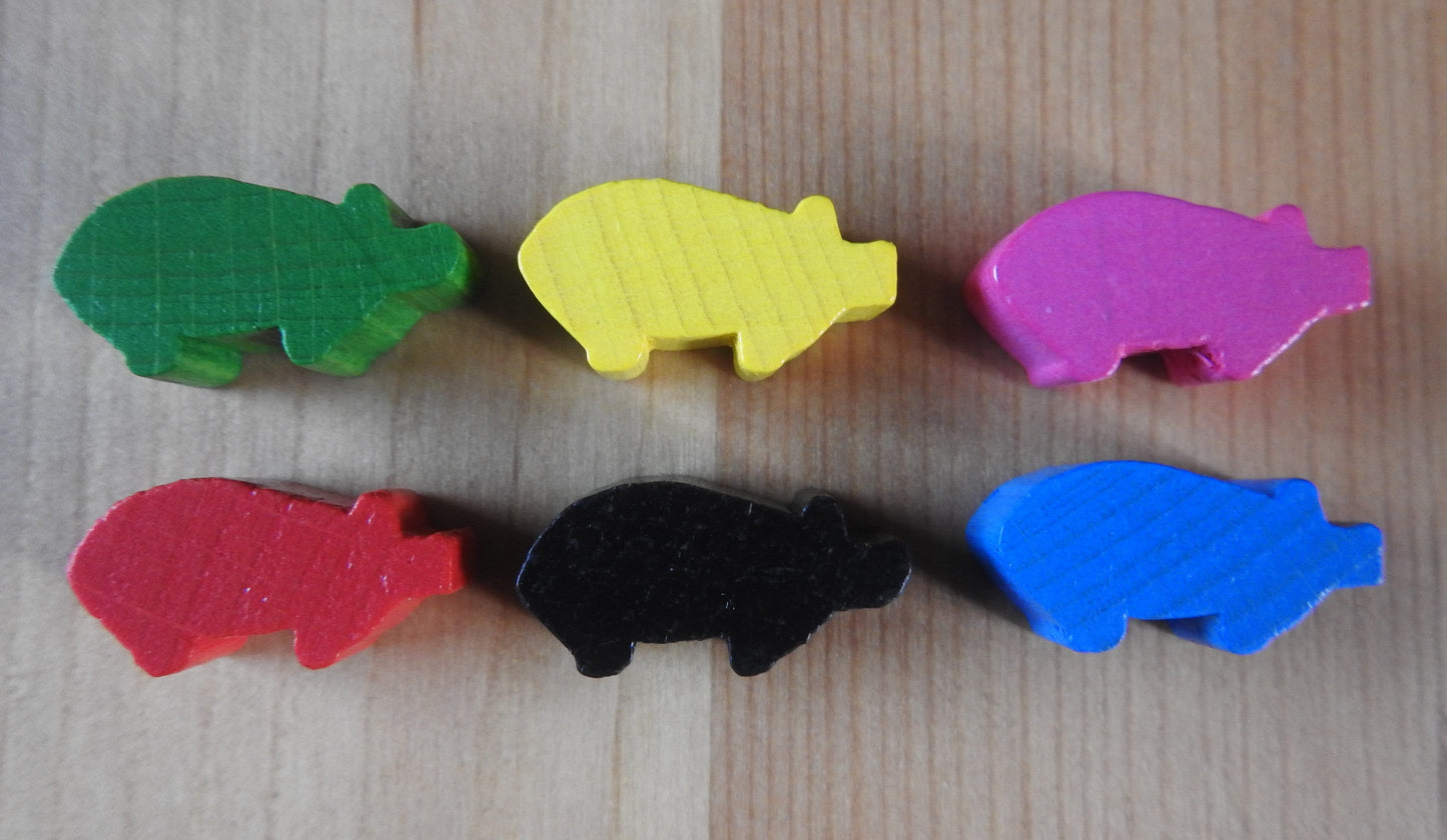 Close-up of all 6 of the wooden pig meeple figures in different colours that are included in this Carcassonne Traders & Builders Unboxed expansion.