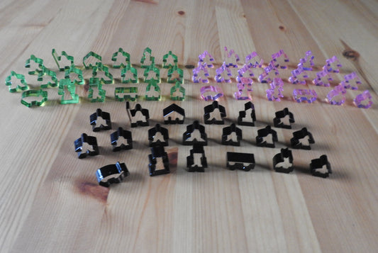 Top view showing 3 of the transparent meeple set colours - light green, pink and black.