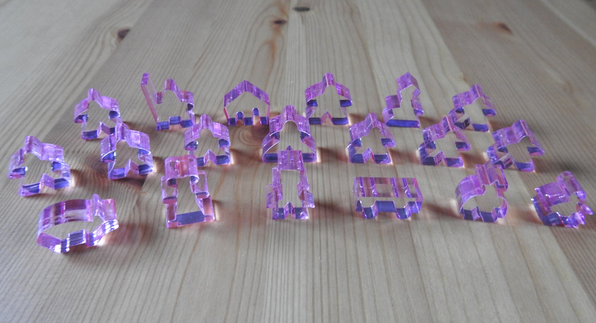 Close-up view of the pink transparent meeple set.