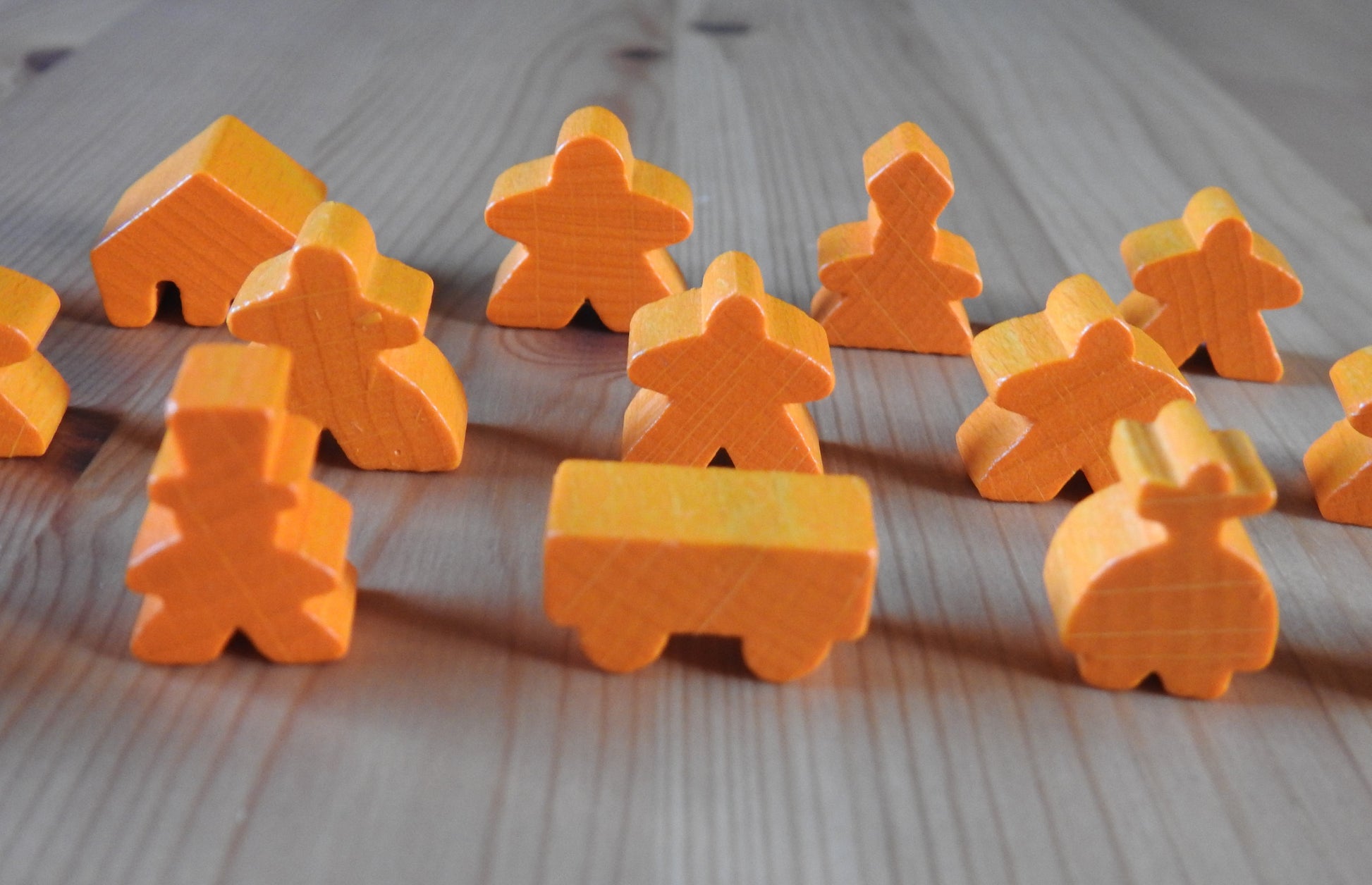 Close-up of the orange ringmaster and other meeples.