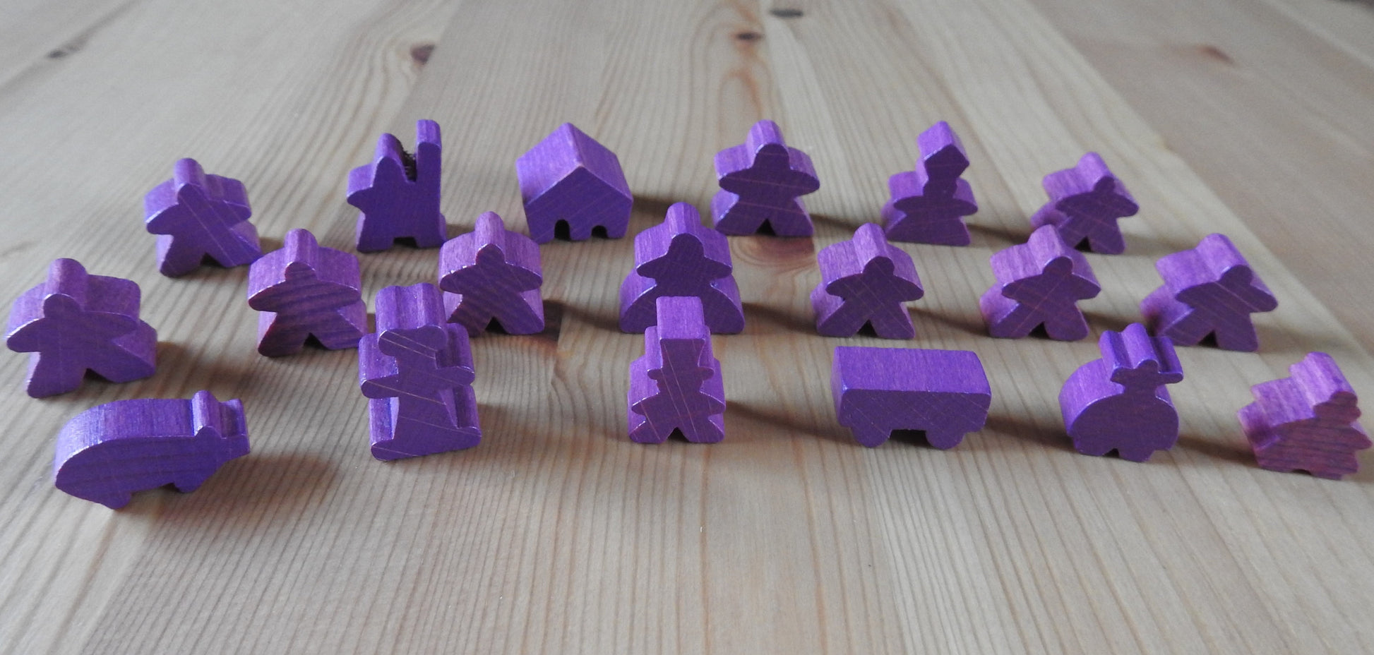 Close-up view of the purple wooden meeple set.